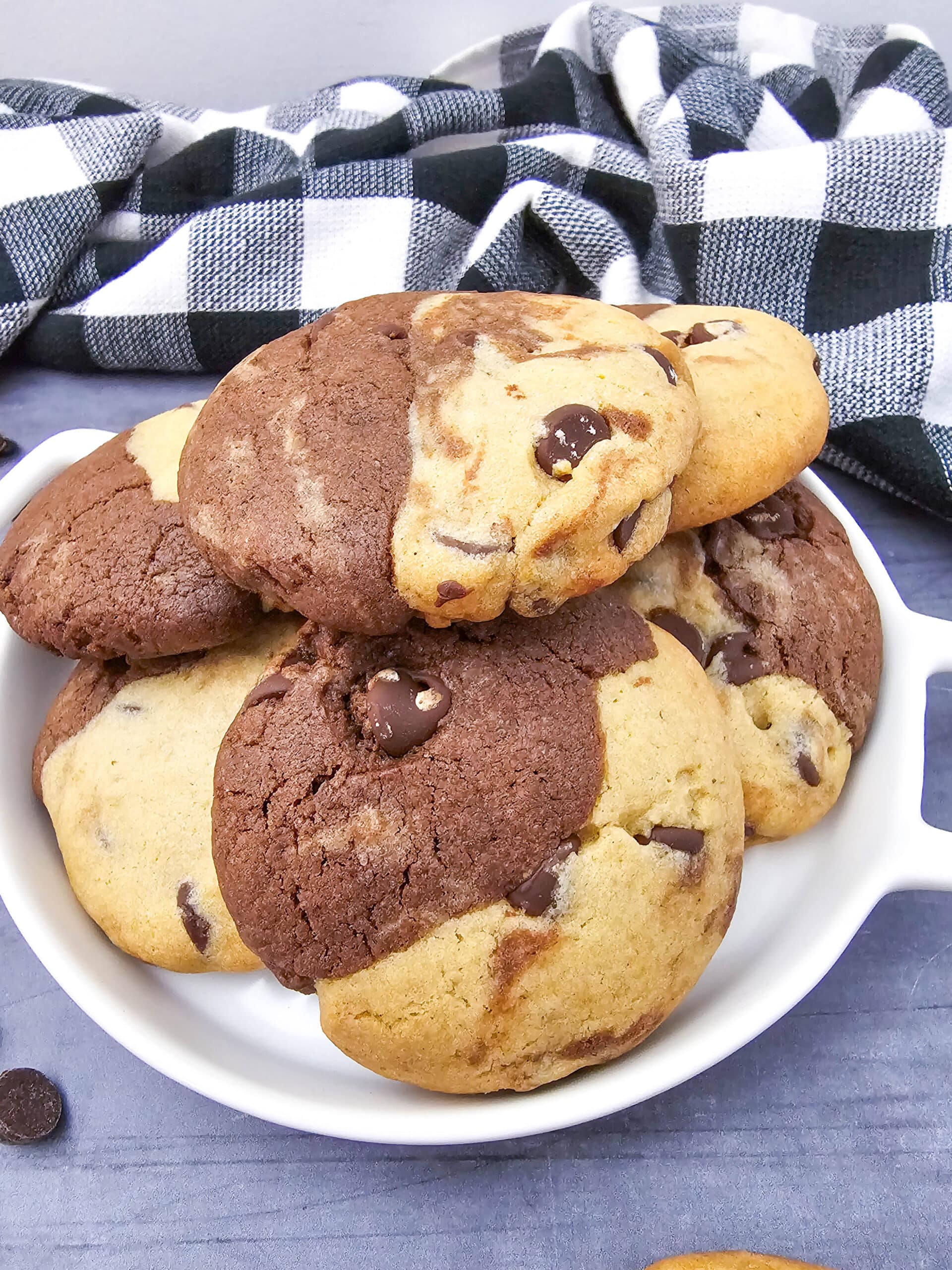 Close-up of a white dish stacked high with brookies recipe cookies showing the distinct brownie and cookie dough halves baked together.