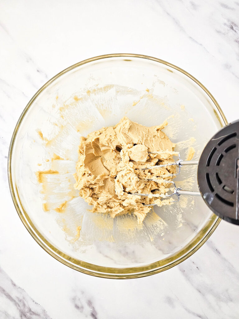 Creamed butter and brown sugar beaten until smooth and fluffy in a glass bowl with a hand mixer.